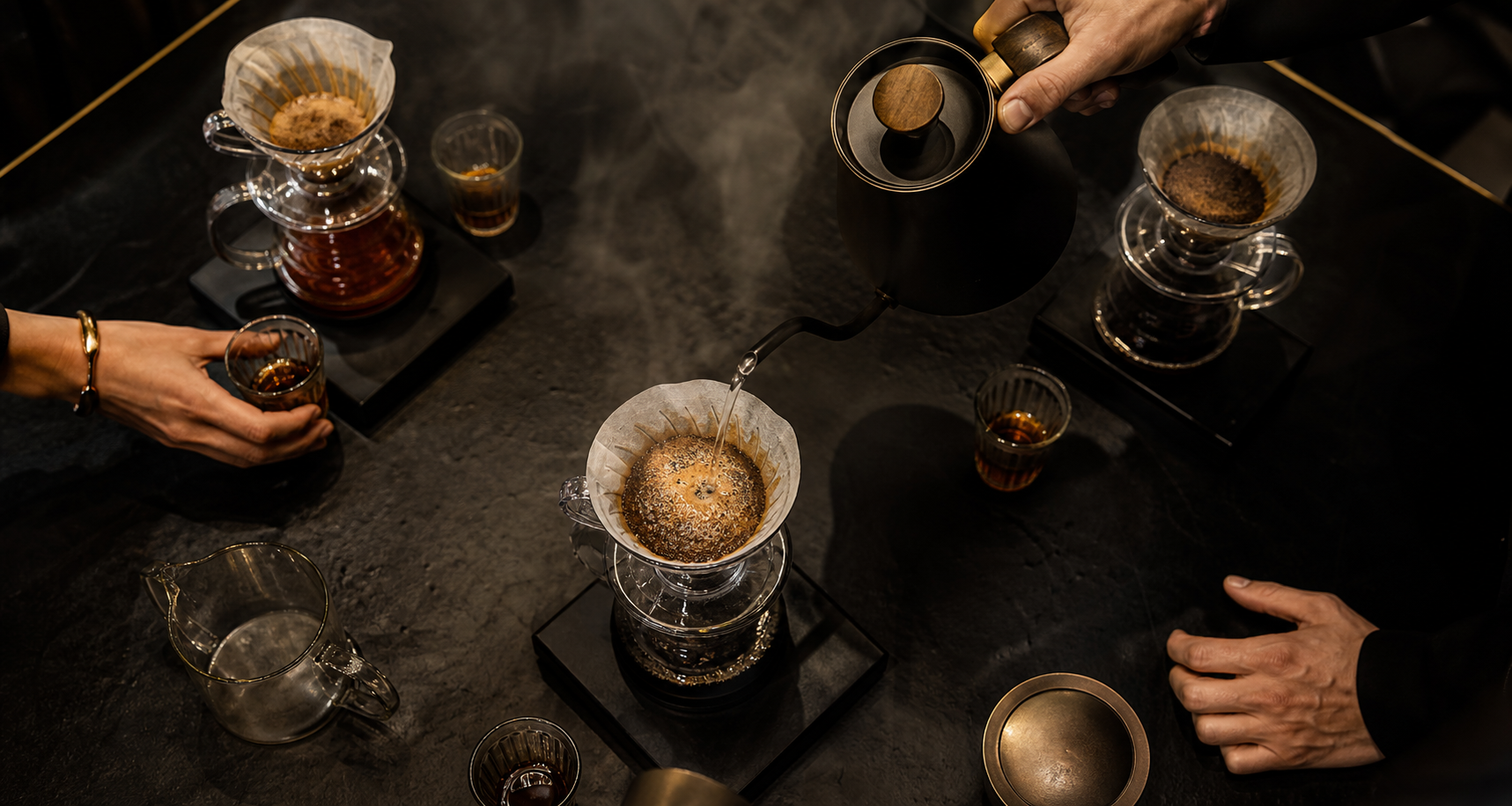 Hands sharing a guided pour-over coffee workshop